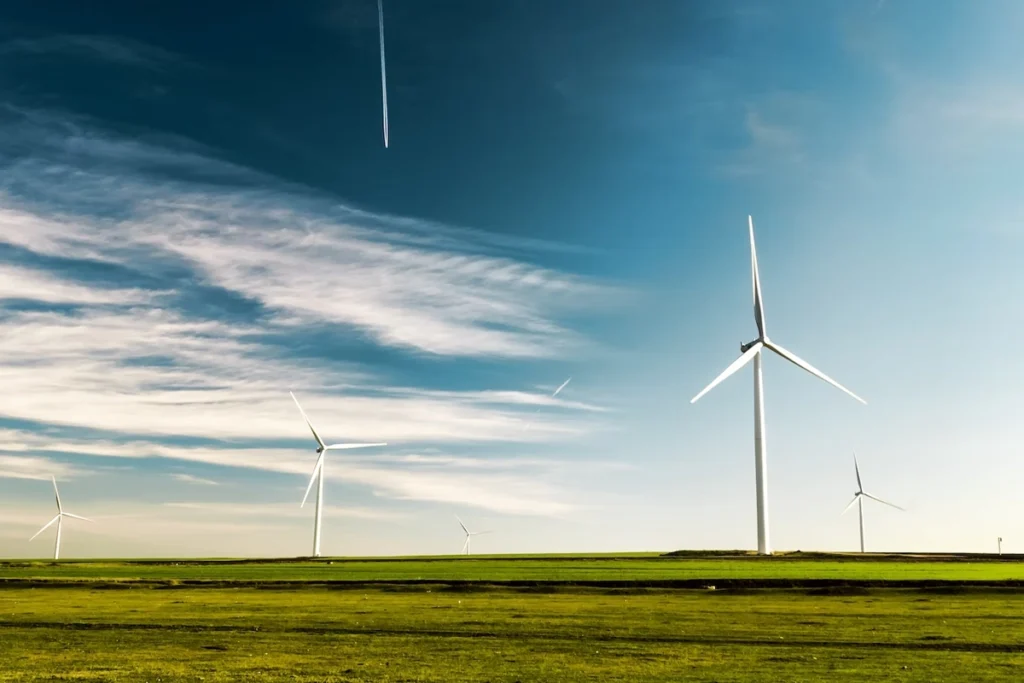 Windkrafträder auf einer grünen Wiese. Sehr weitläufig, erneuerbare Energie.